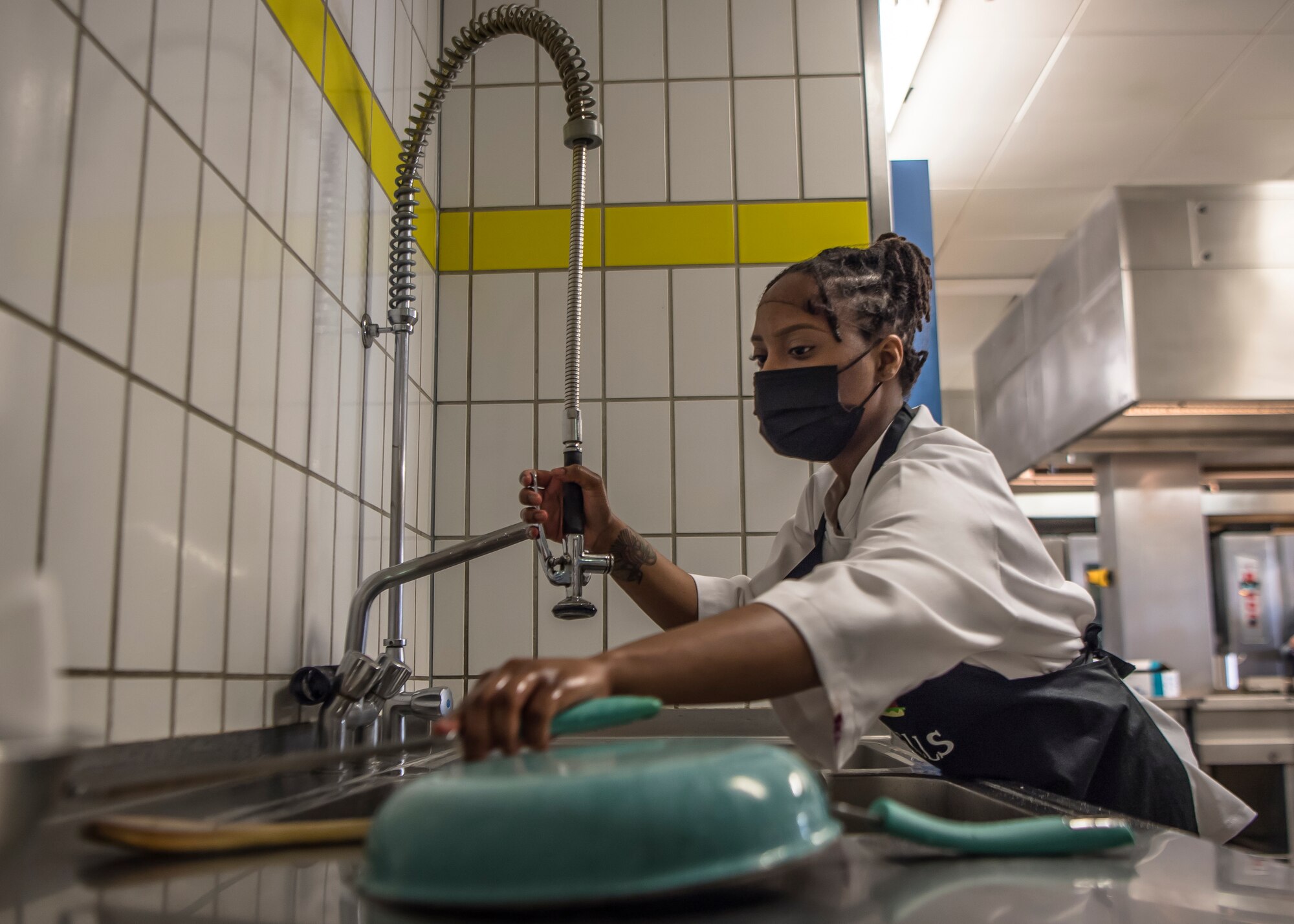 A woman washes dishes.