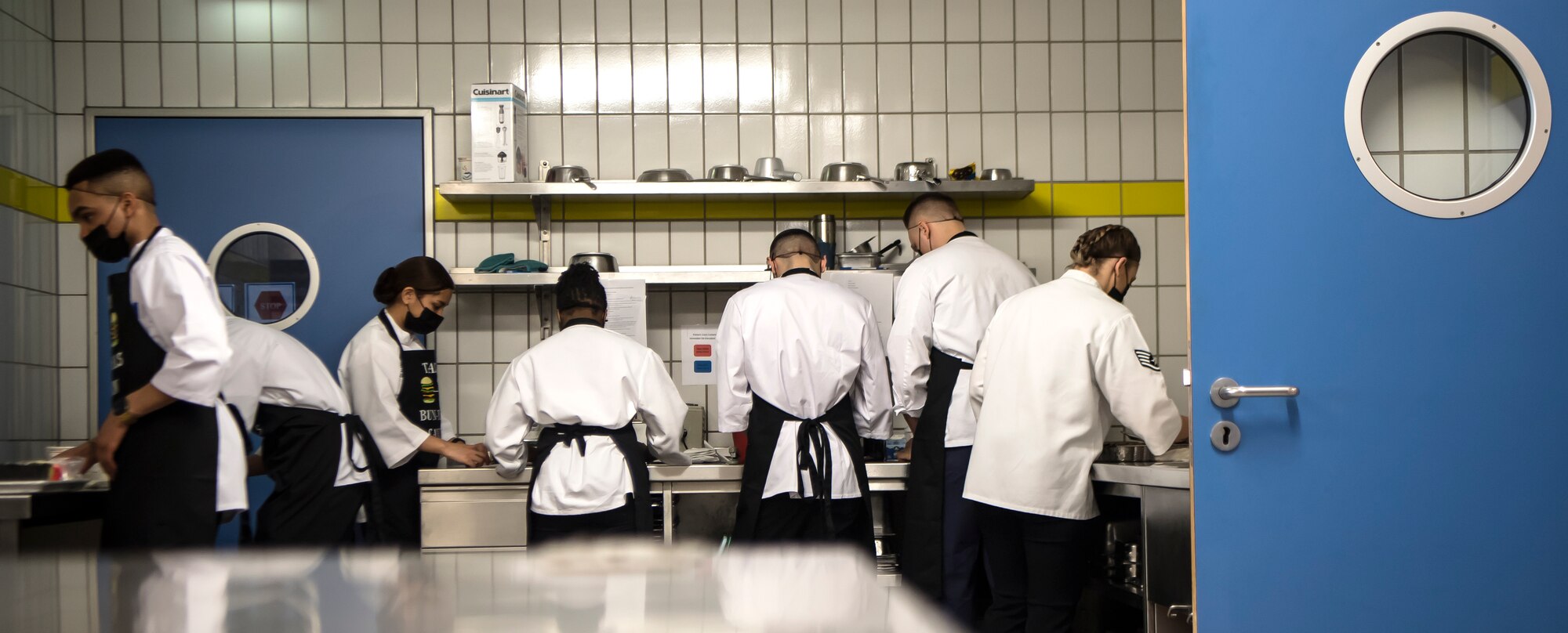 Several people work at their food prep stations.