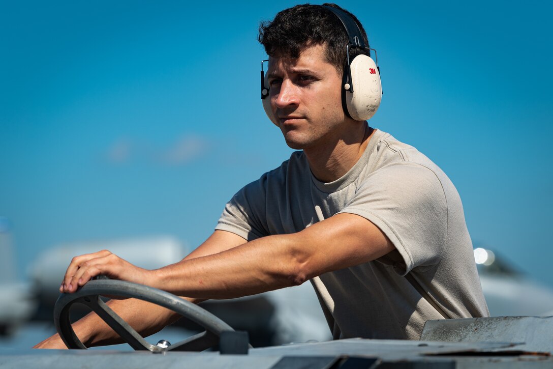 A photo of an Airman operating a weapons loader