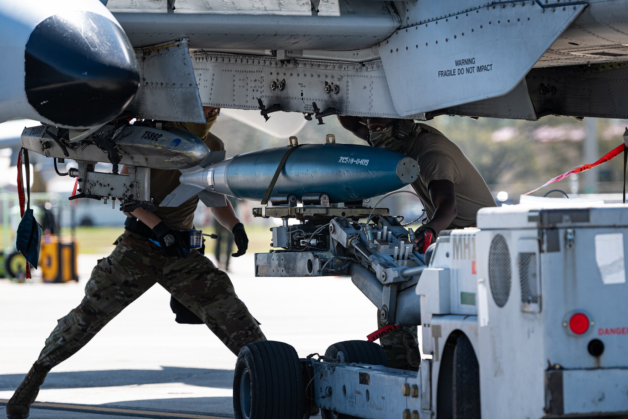 A photo of Airmen loading bombs onto an aircraft