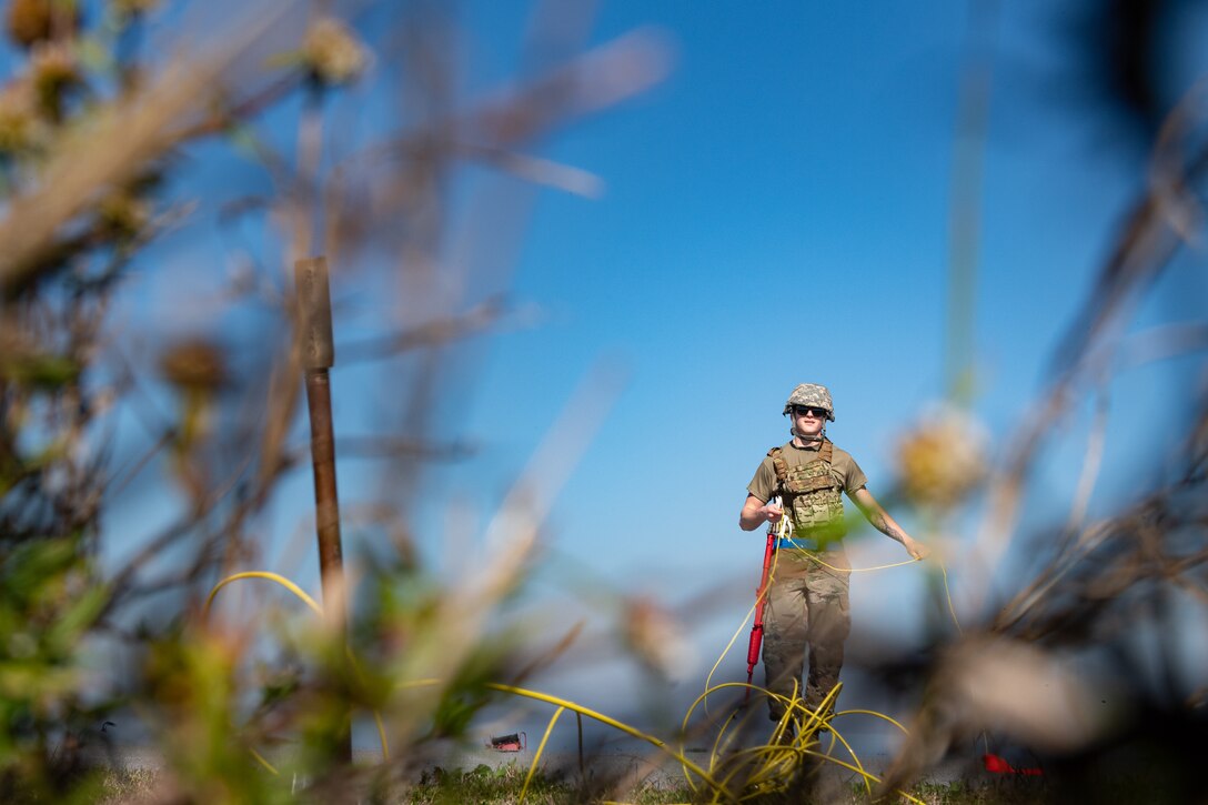 A photo of an Airman unraveling grounding wire