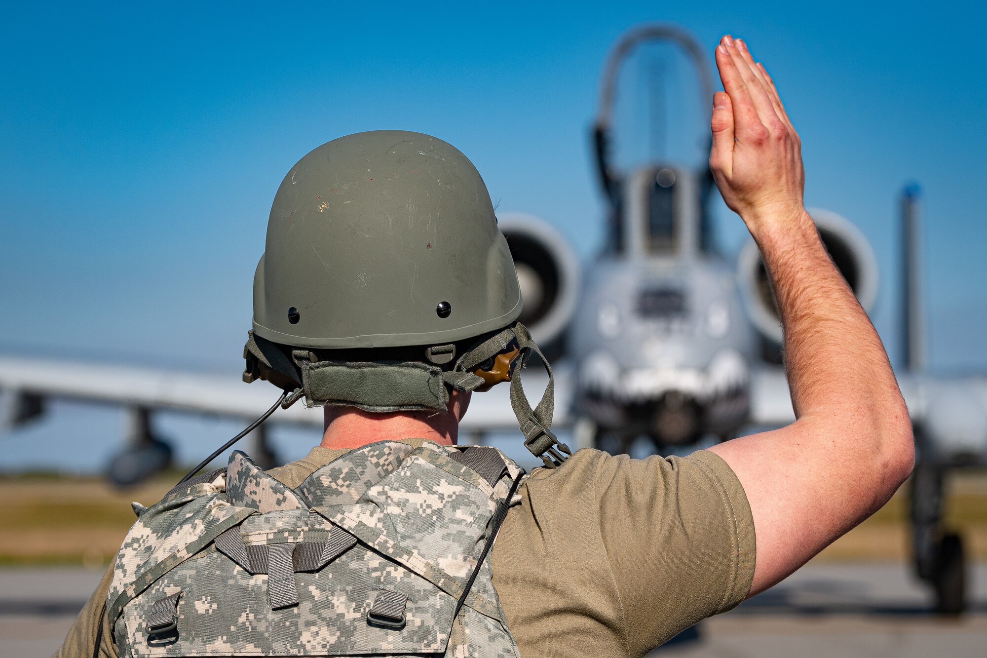 A photo of an Airman marshalling an aircraft