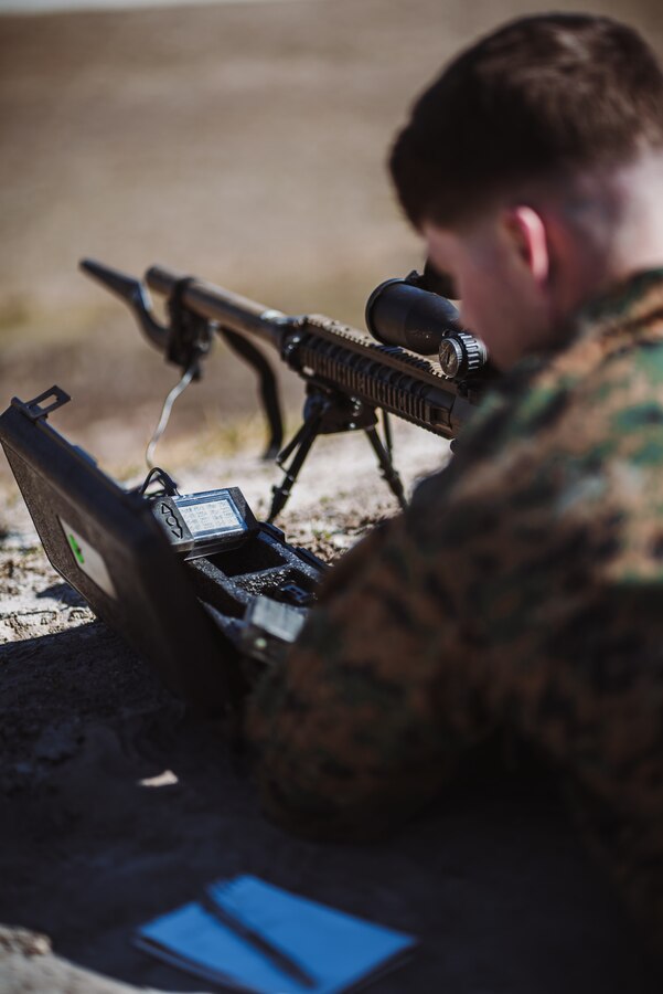 A U.S. Marine with 2d Reconnaissance Battalion (2d Recon Bn.), 2nd Marine Division checks his equipment before firing on range G-12, Camp Lejeune, N.C., March 8, 2021.