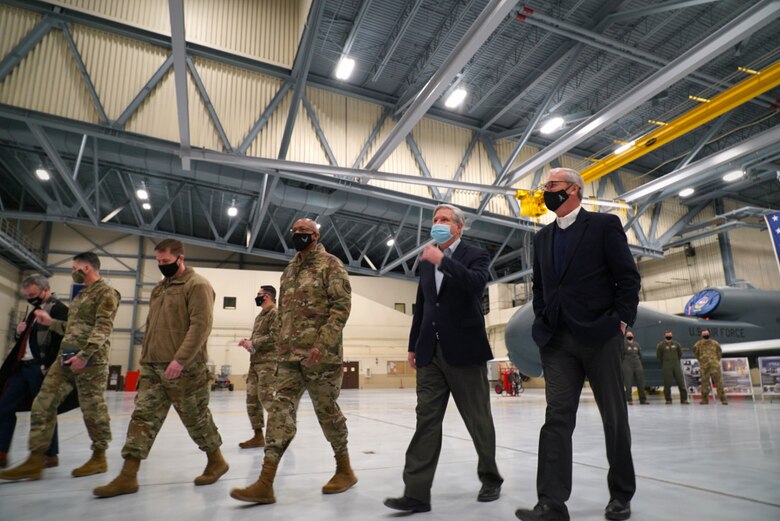 Col. Cameron Pringle, 319th Reconnaissance Wing commander, (third from left), Air Force Chief of Staff Gen. Charles Q. Brown, Jr., Sen. John Hoeven and Senator Kevin Cramer, depart an aircraft hangar at Grand Forks Air Force Base, N.D., Feb. 17, 2021. Brown received a brief from members of the 319th Aircraft Maintenance Squadron, who shared information regarding the critical role the RQ-4 Global Hawk plays in the Air Force's intelligence, surveillance and reconnaissance mission. (U.S. Air Force photo by Staff Sgt. Elora J. McCutcheon)