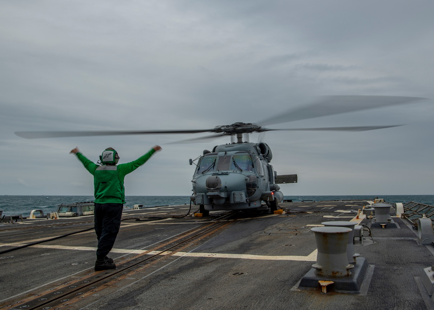 210310-N-SS350-1022 EAST CHINA SEA (March 10, 2021) U.S. Navy Aviation Electrician’s Mate 2nd Class Elizabeth Larson, from Porter, Texas, assigned to the “Magicians” of Helicopter Maritime Strike Squadron (HSM) 35, signals to the pilots in an MH-60R Sea Hawk on the flight deck of the Arleigh Burke-class guided-missile destroyer USS John Finn (DDG 113) March 10, 2021. John Finn, part of the Theodore Roosevelt Carrier Strike Group, is on a scheduled deployment to the U.S. 7th Fleet area of operations. As the U.S. Navy’s largest forward-deployed fleet, 7th Fleet routinely operates and interacts with 35 maritime nations while conducting missions to preserve and protect a free and open Indo-Pacific Region. (U.S. Navy photo by Mass Communication Specialist 3rd Class Jason Waite)