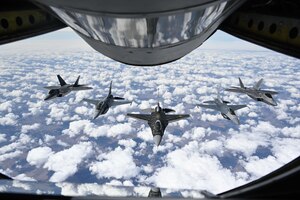 Pilots with the F-16 Viper and F-22 Raptor Demonstration Teams fly behind a KC-135 Stratotanker from the 465th Air Refueling Squadron assigned to Tinker Air Force Base, Oklahoma March 8, 2021. The F-16 team from Shaw Air Force Base, South Carolina, and the F-22 team from Joint Base Langley–Eustis, Virginia, are assigned to Air Combat Command and received fuel from the Okies during their flight back to their home stations after performing at an air show. (U.S. Air Force photo by Senior Airman Mary Begy)