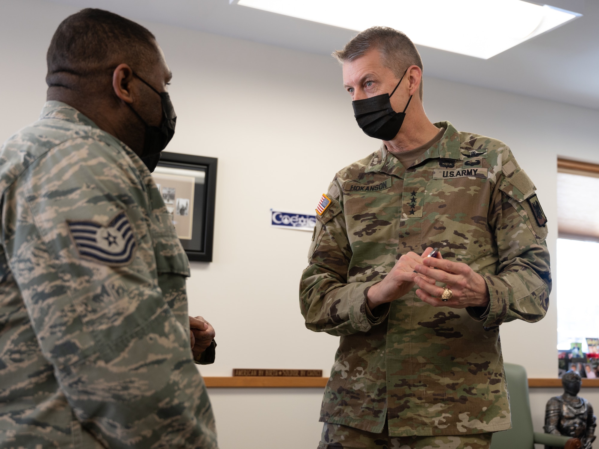 U.S. Army General Daniel R. Hokanson, chief, National Guard Bureau, presents a coin to Technical Sgt. Kirby Addison, Airman assigned to the 158th Fighter Wing.
