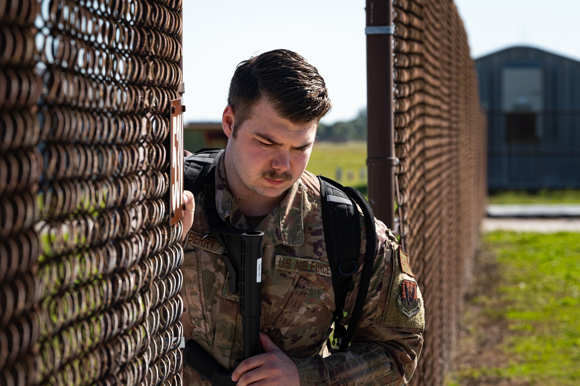 A photo of an Airman opening a gate