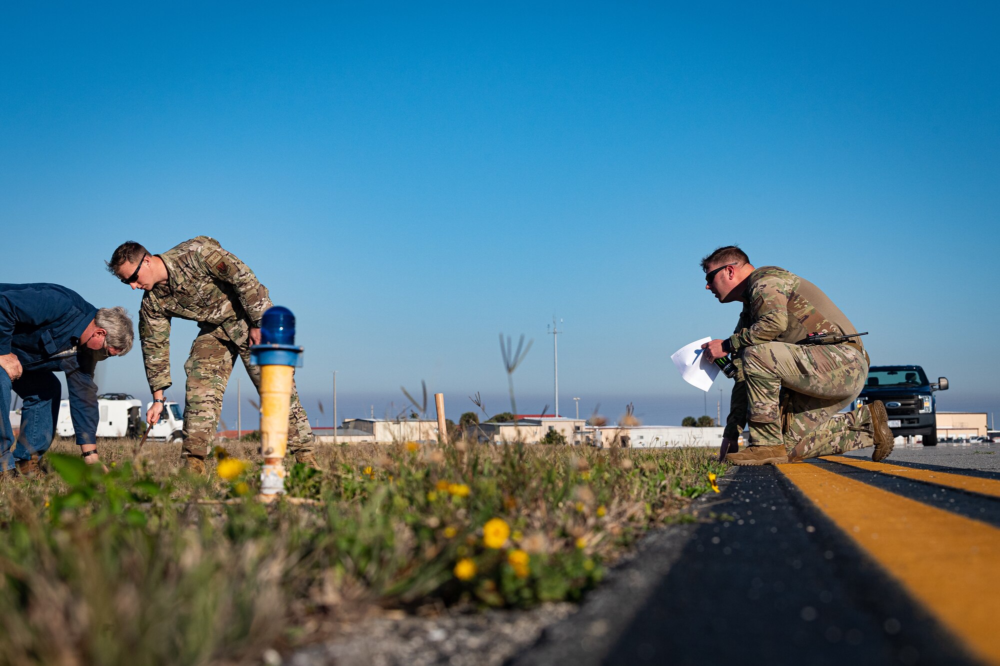 A photo of Airmen placing grounding rods on an airfield