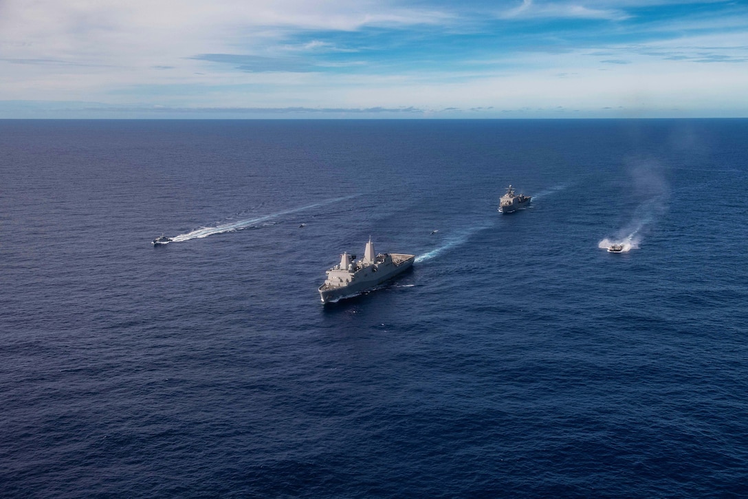 Navy vessels travel in formation.