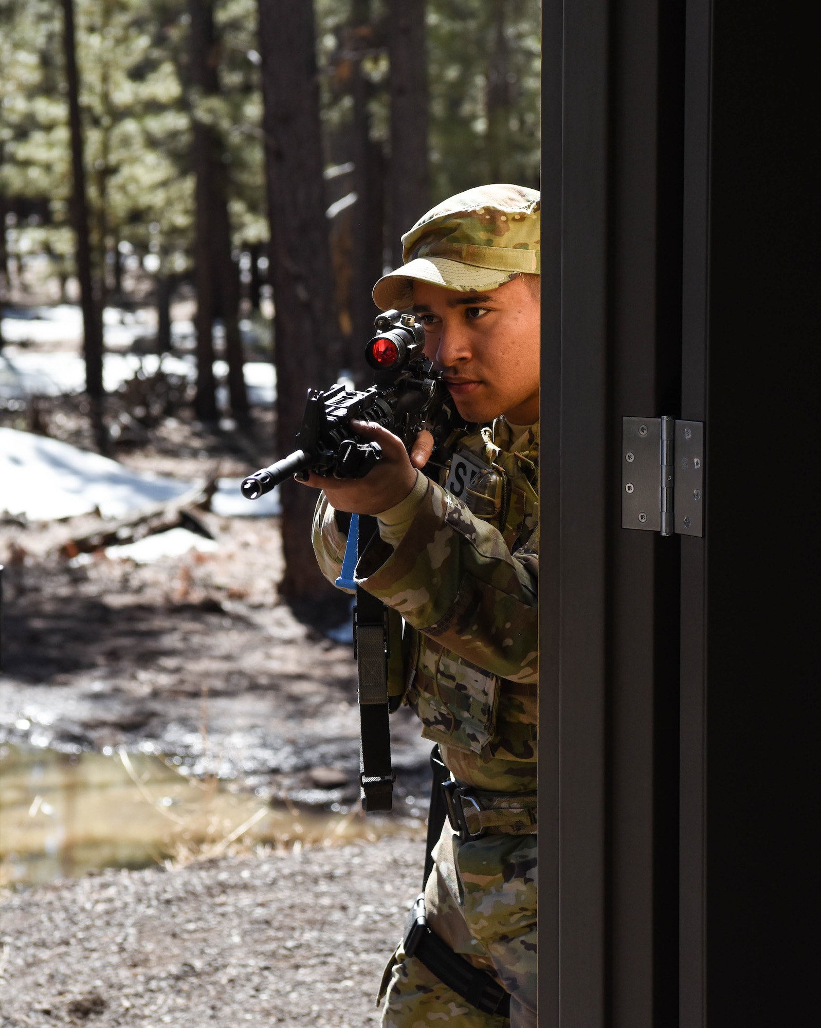 Airman 1st Class Juan Batiz Ocon, 944th Security Forces Squadron fire team member, takes his position while practicing close quarter battle tactics during a deployment training exercise, March 6, 2021 at Camp Navajo, Bellemont, Arizona. During the four-day exercise, Airmen participated in classroom instruction and hands-on training including recovery missions, land navigation, weapons qualification, and base security operations.
