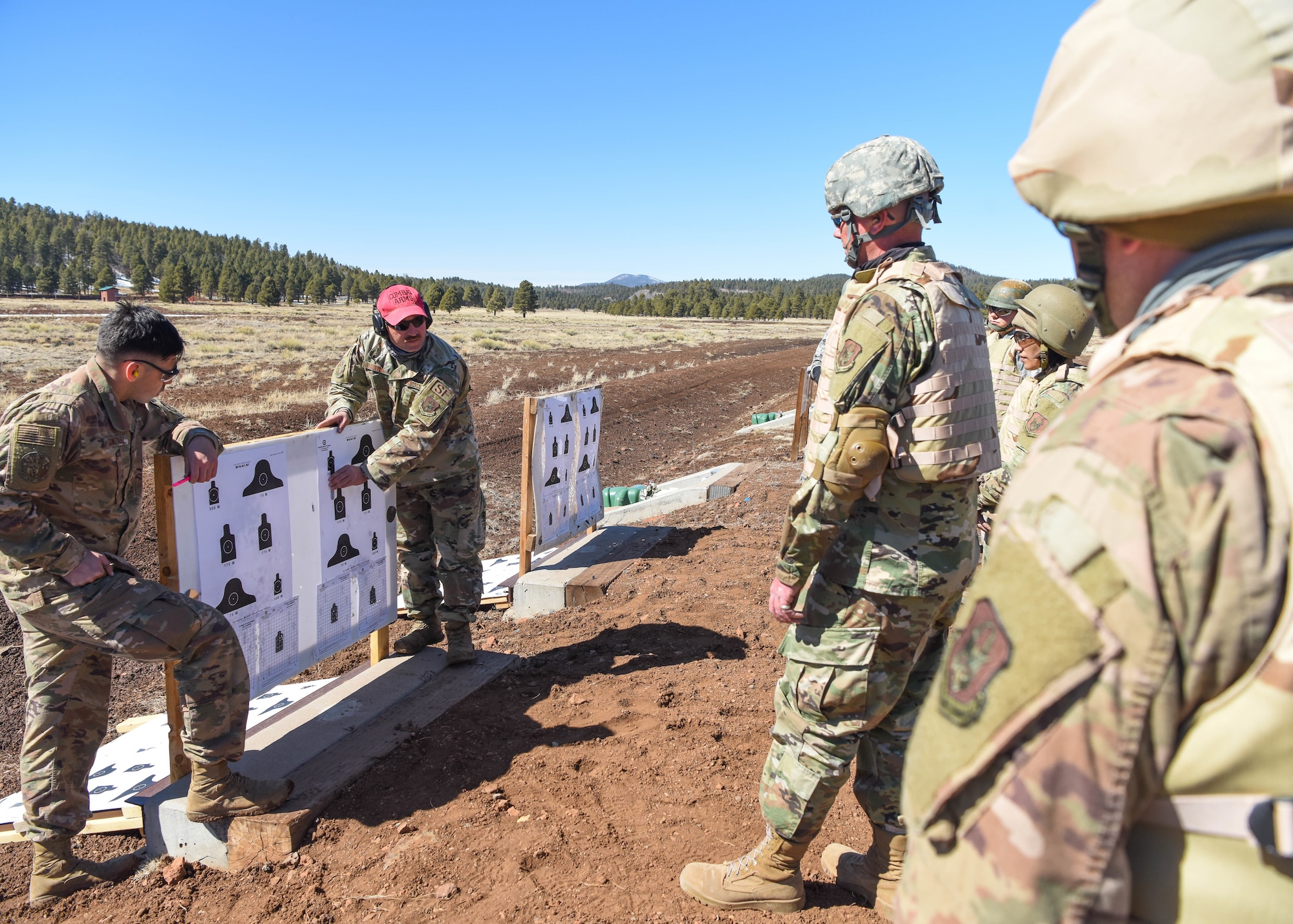 Master Sgt. Jerry Guerra, 944th Security Forces Squadron combat arms superintendent, gives trainees advice on improving their aim during a deployment training exercise, March 6, 2021 at Camp Navajo, Bellemont, Arizona. The first-of-its-kind exercise was conducted by the 944th MSG, aimed at bringing together four different squadrons with different missions in a simulated deployed environment.