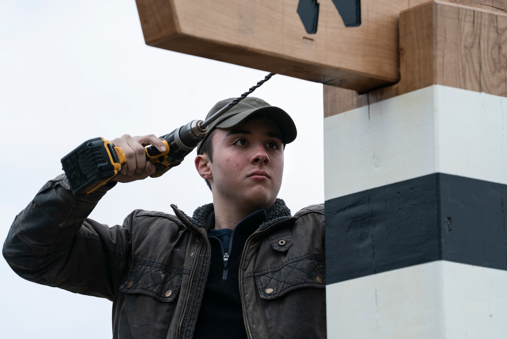 Cole Heard, son of Lt. Col. Jason Heard, 48th Fighter Wing Chief of Plans and Programs, drills into the top structure of the arch during construction at Royal Air Force Lakenheath, England, March 6, 2021. The arch was built as an Eagle Scout project, an opportunity for a Scout to demonstrate leadership abilities while completing a project for the benefit of their community. (U.S. Air Force photo by Airman 1st Class Jessi Monte)
