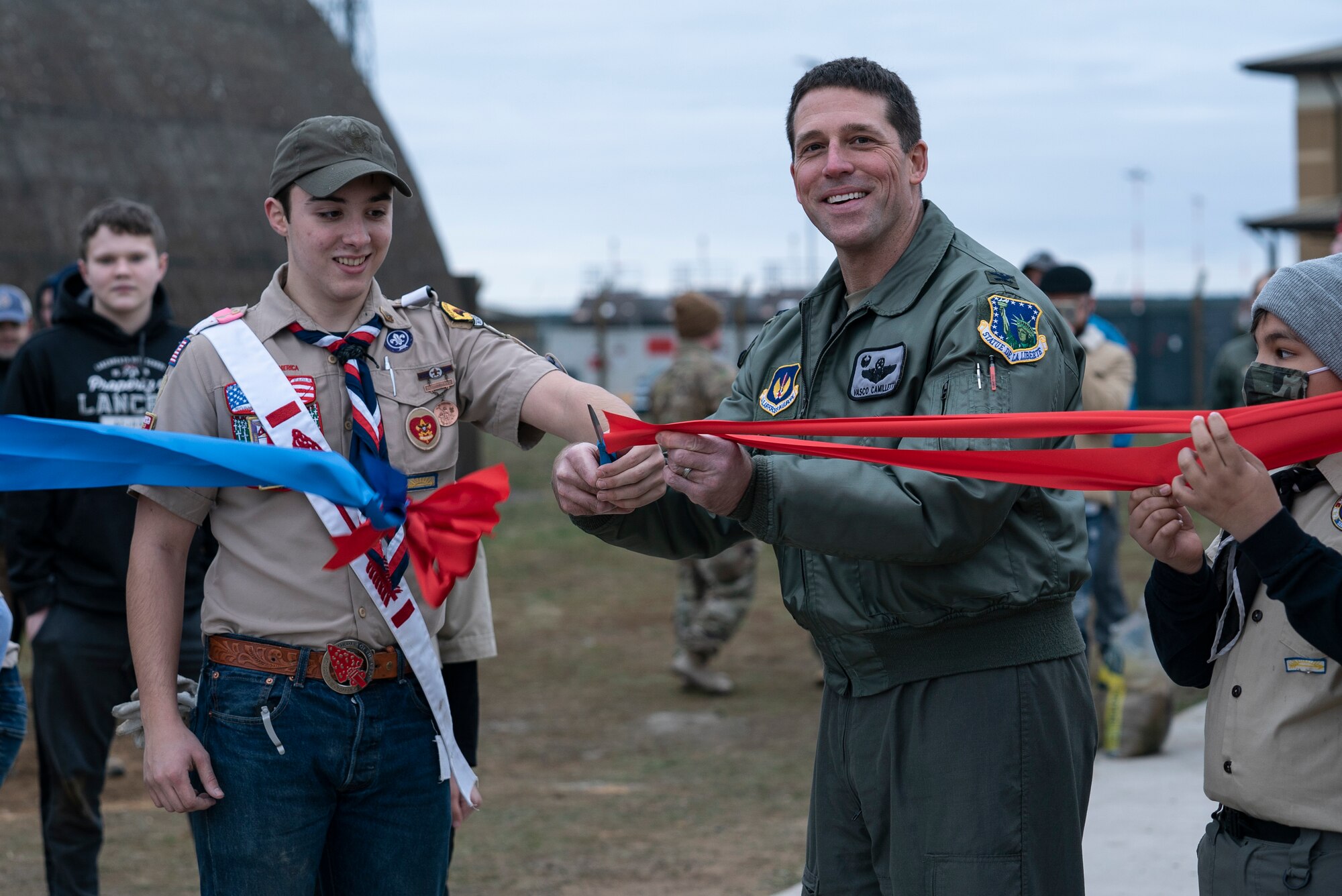 U.S. Air Force Col. Jason Camilletti, 48th Fighter Wing commander, and Cole Heard, son of Lt. Colonel Jason Heard, 48th Fighter Wing Chief of Plans and Programs, cut the ribbon to signify the official opening of the heritage arch outside the Strike Eagle Complex at Royal Air Force Lakenheath, England, March 6, 2021. The arch was built as an Eagle Scout project, an opportunity for a Scout to demonstrate leadership abilities while completing a project for the benefit of their community. (U.S. Air Force photo by Airman 1st Class Jessi Monte)