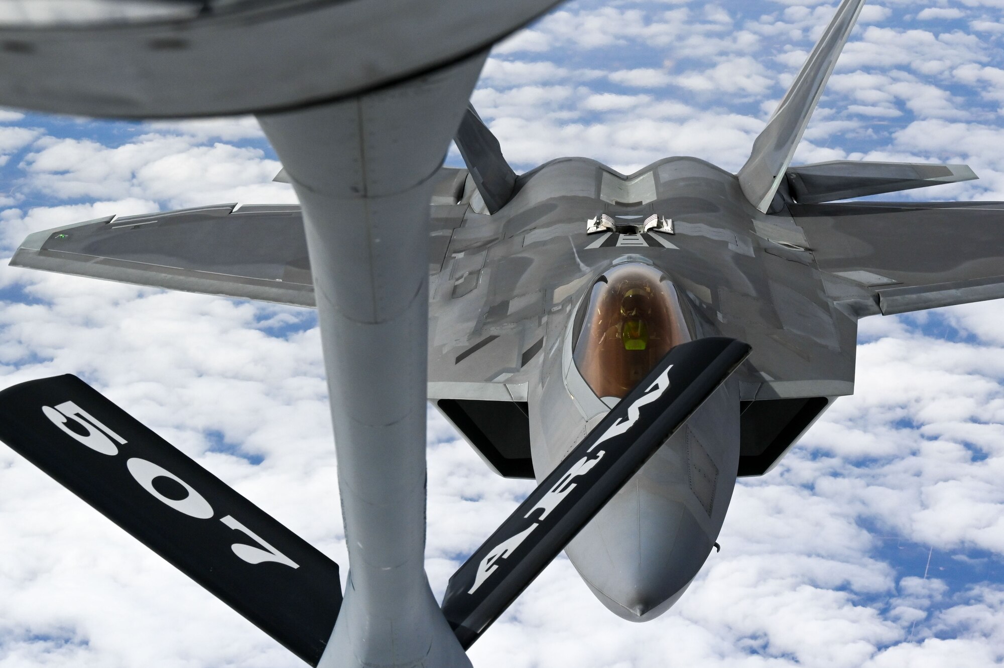 An F-22 Raptor Demonstration Team pilot refuels with a KC-135 Stratotanker from the 465th Air Refueling Squadron assigned to Tinker Air Force Base, Oklahoma, March 8, 2021. The F-22 team from Joint Base Langley–Eustis, Virginia, is assigned to Air Combat Command and received fuel from the Okies during their flight back to their home station after performing at an air show. (U.S. Air Force photo by Senior Airman Mary Begy)