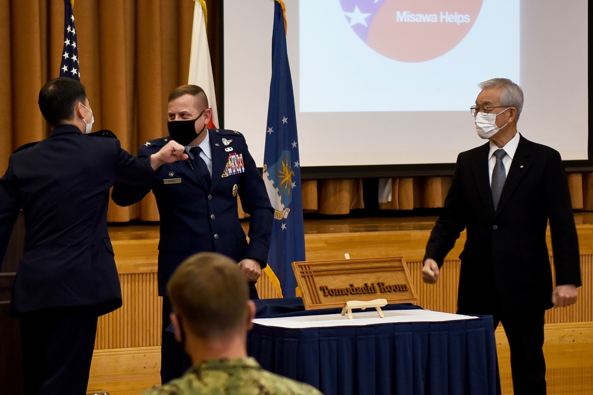 Three men reveal a sign