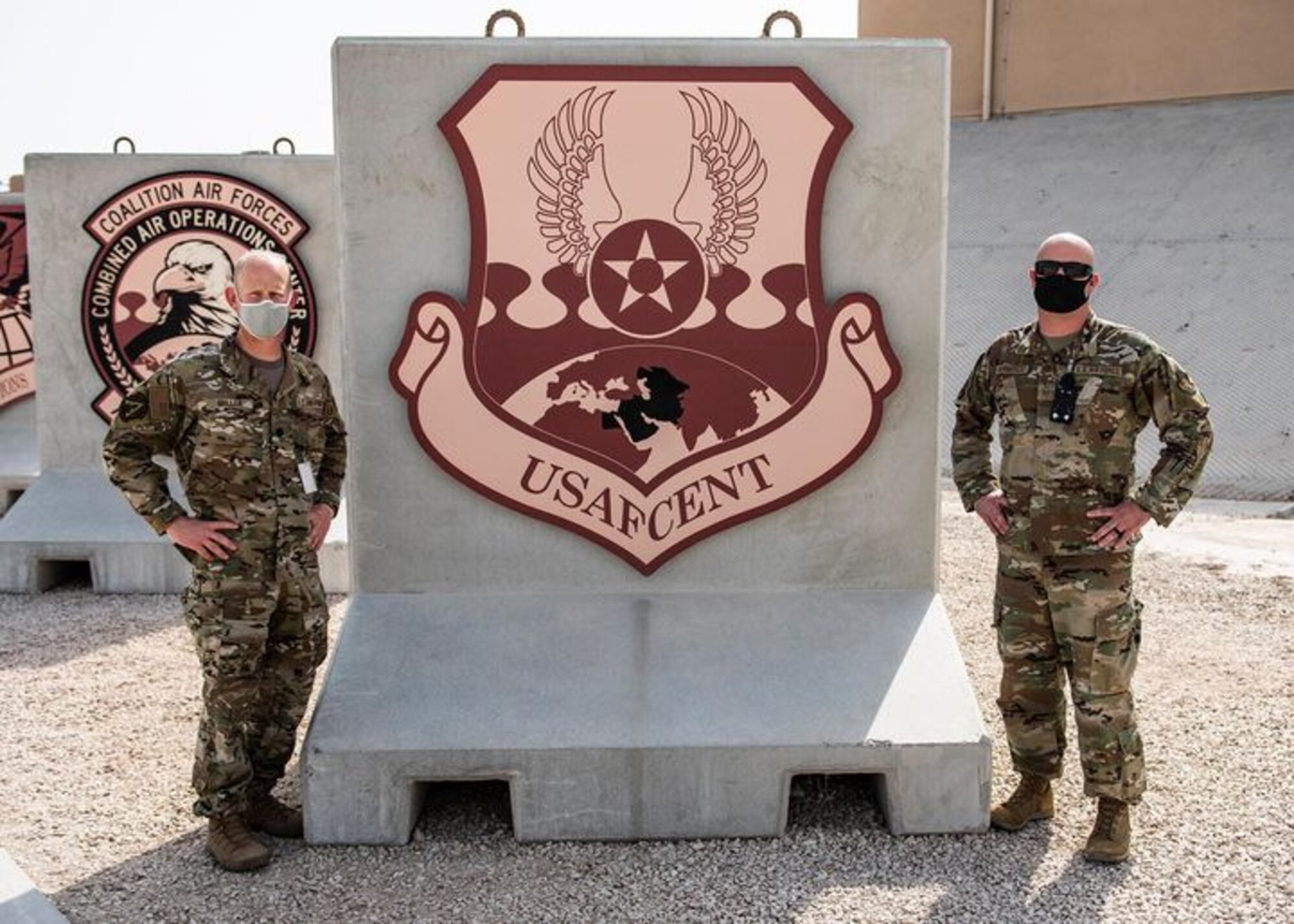 U.S. Air Force Lt. Col. Jake Miller (left), U.S. Air Forces Central deputy chief of staff, and Master Sgt. Tyler Kermoade (right), 609th Expeditionary Air Communications Squadron plans and programs flight chief, pose for a photo outside the Combined Air Operations Center at Al UDeid Air Base, Qatar, March 10, 2021.