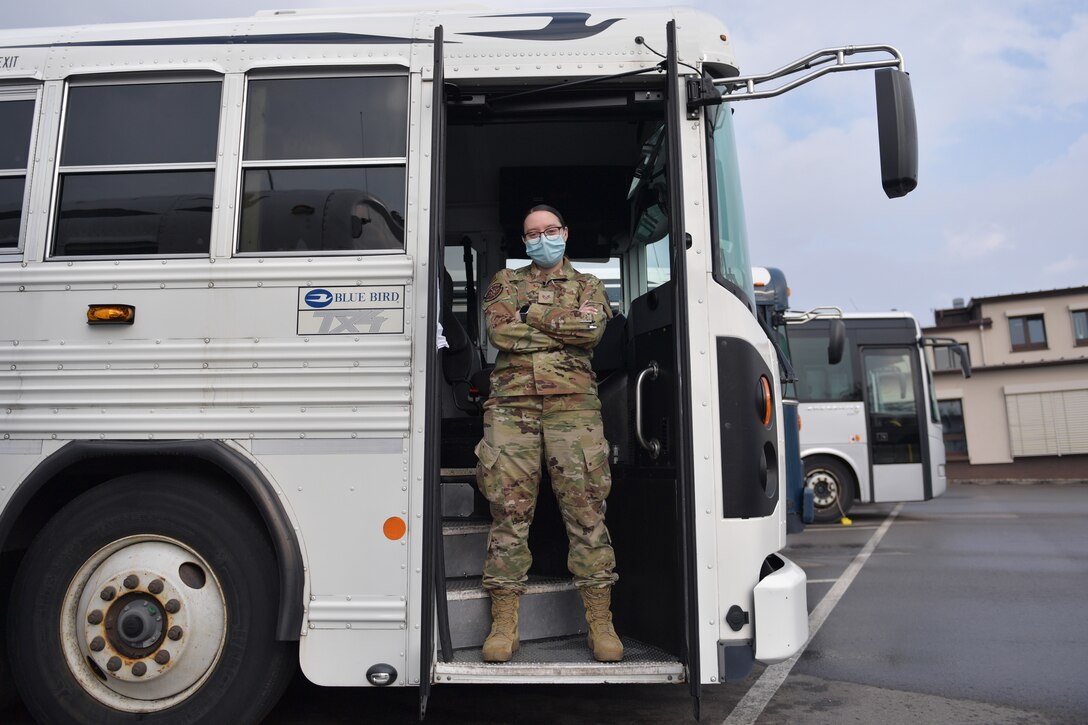 Airman standing in the door of a bus.