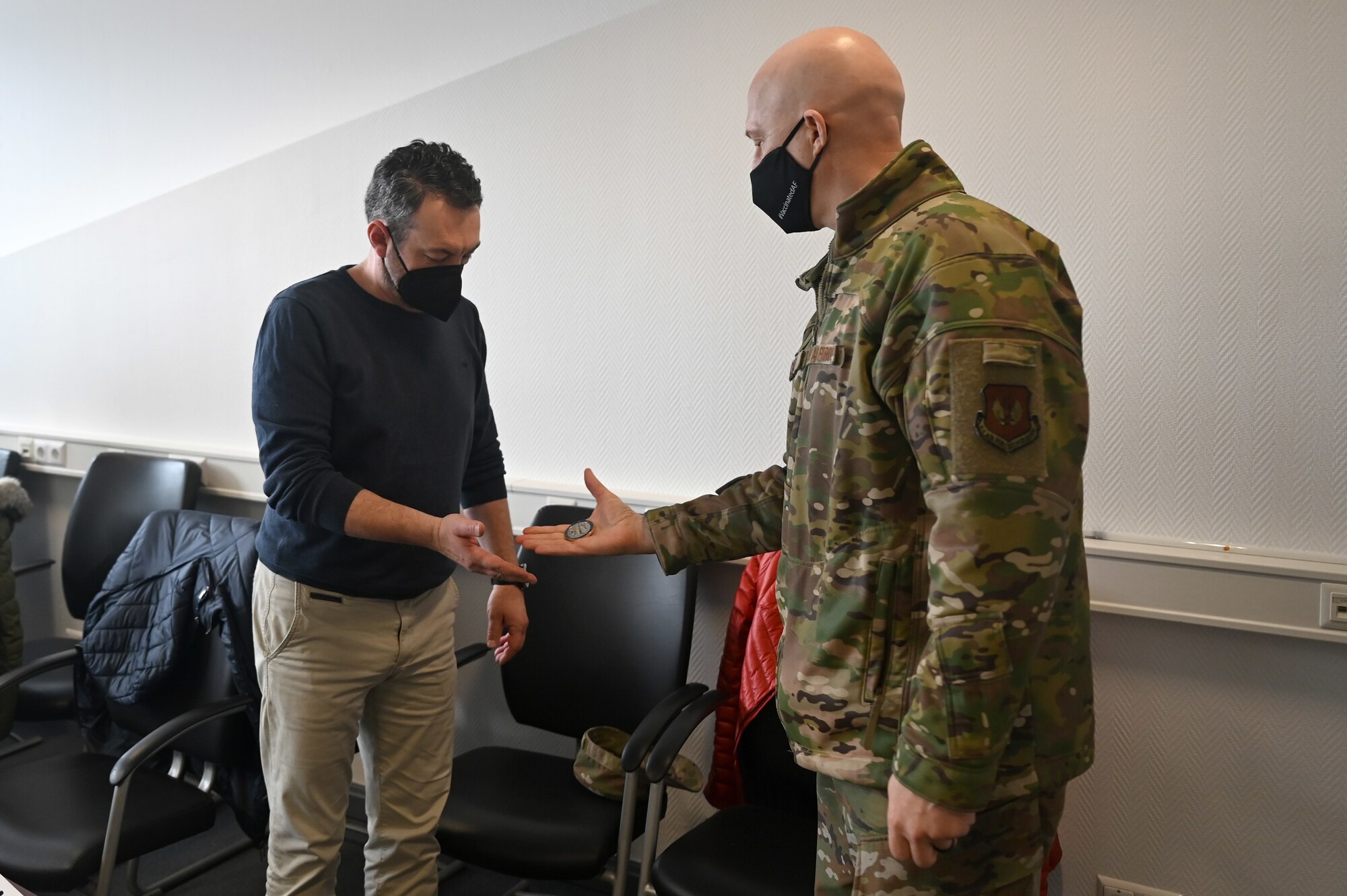 Sascha Lindauer, 786th Civil Engineer Squadron contract officer representative, accepts a coin from U.S. Air Force Brig. Gen. Josh Olson, 86th Airlift Wing commander, during a recognition ceremony