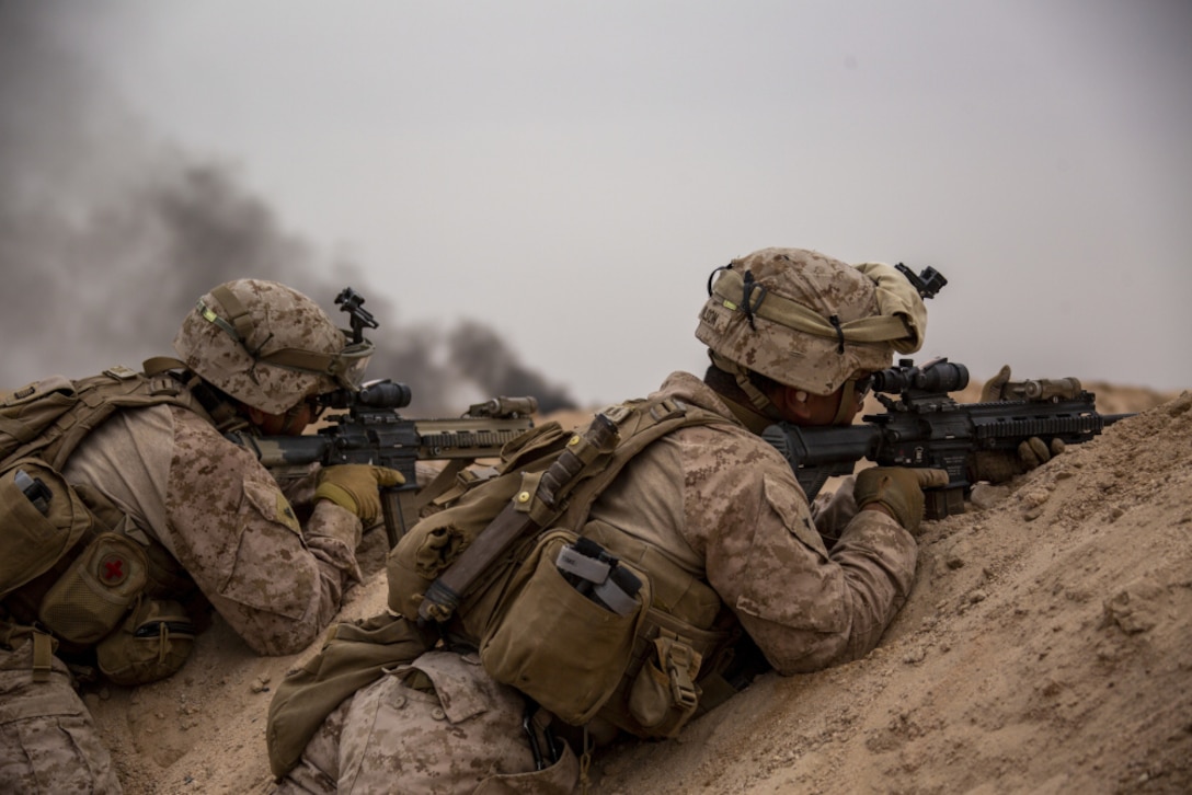 Marine Corps Cpl. Justin Machado, left, and Lance Cpl. Losia V.A. Wilson, both riflemen assigned to Charlie Company, Battalion Landing Team 1/4, 15th Marine Expeditionary Unit, provide security after completing a simulated assault for a company-sized live-fire attack exercise during a theater amphibious combat rehearsal at Camp Buehring, Kuwait, Feb. 23.