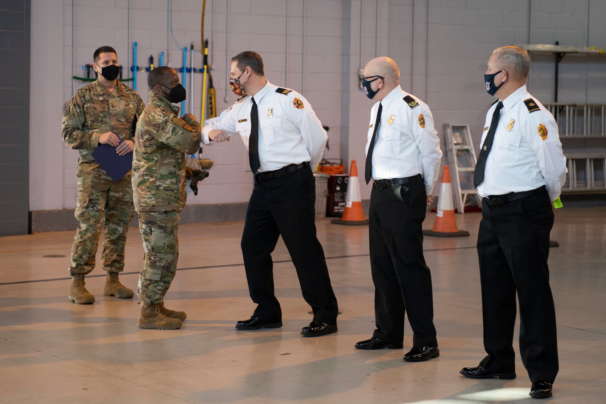 U.S. Air Force Brig. Gen. Ronald E. Jolly Sr., left, U.S. Air Forces in Europe and Air Forces Africa logistics, engineering and force protection director, greets the 423rd Civil Engineer  Squadron fire department at Royal Air Force Alconbury, England, March 10, 2021. The 501st CSW hosted an immersion tour for Jolly and his leadership team, demonstrating the mission set and capabilities of several organizations including the security forces, logistics readiness and civil engineer squadrons. (U.S. Air Force photo by Senior Airman Jennifer Zima)