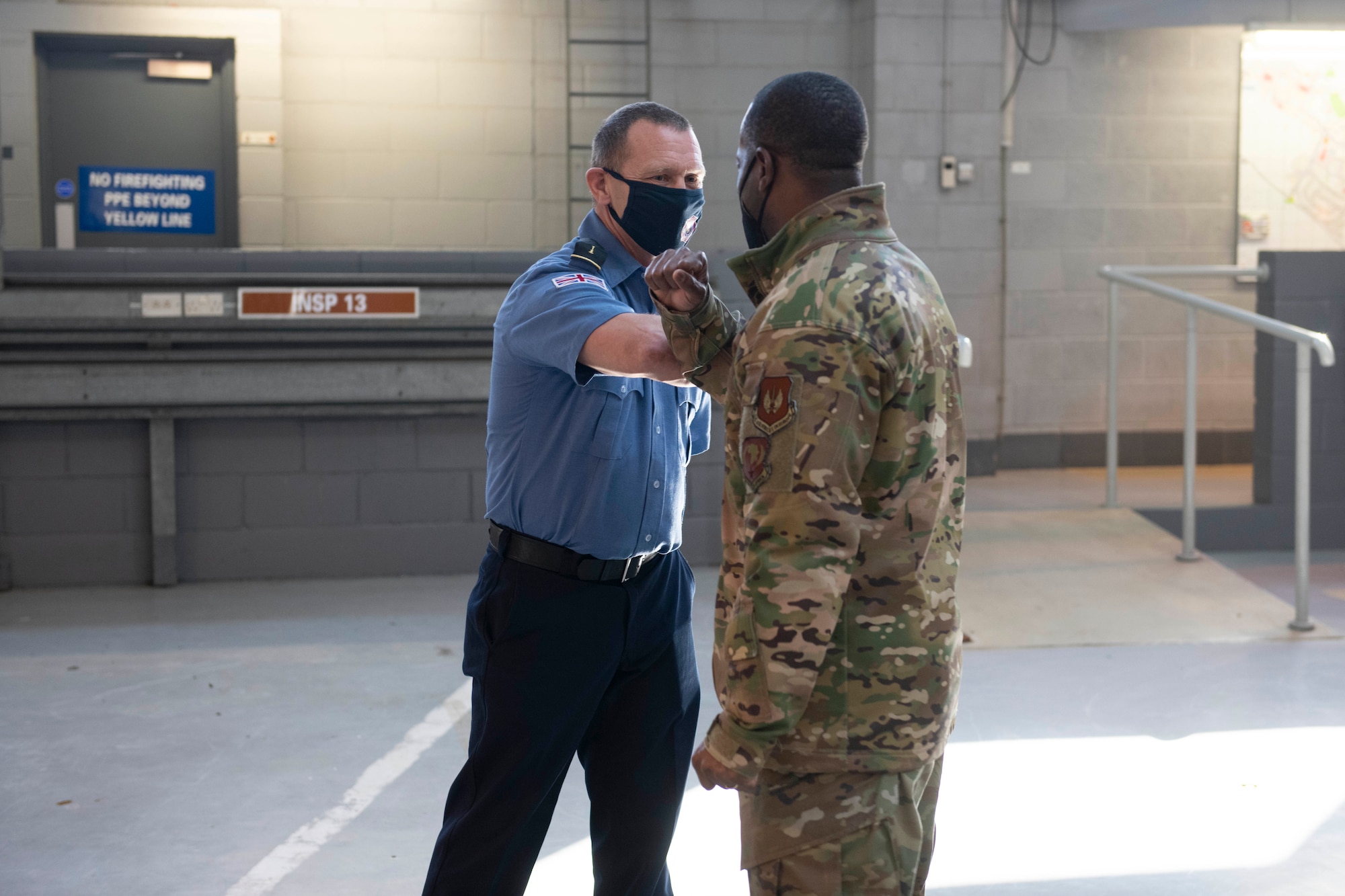 U.S. Air Force Brig. Gen. Ronald E. Jolly Sr., right, U.S. Air Forces in Europe and Air Forces Africa logistics, engineering and force protection director, greets a 423rd Civil Engineer  Squadron firefighter at Royal Air Force Alconbury, England, March 10, 2021. The 501st CSW hosted an immersion tour for Jolly and his leadership team, demonstrating the mission set and capabilities of several organizations including the security forces, logistics readiness and civil engineer squadrons. (U.S. Air Force photo by Senior Airman Jennifer Zima)