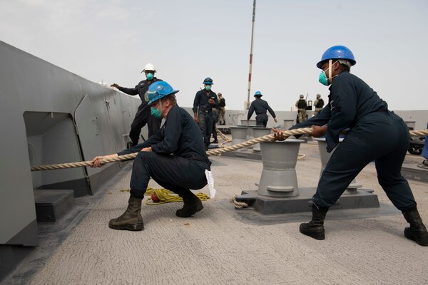 Seaman Jakob Scott, left, and Seaman Kahvia Ivens heave in line on the forecastle of amphibious transport dock ship USS San Diego (LPD 22) as the ship departs Manama, Bahrain.