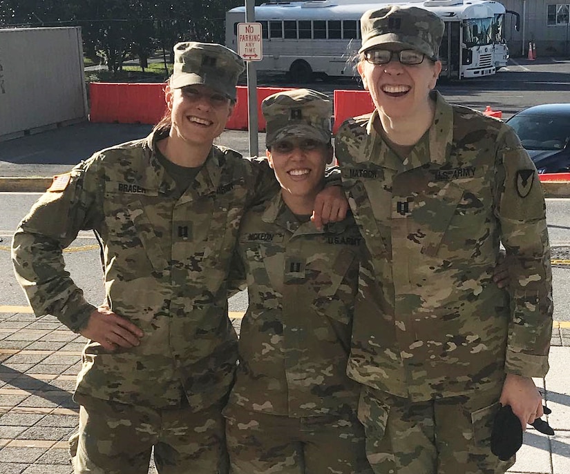 Three women in military uniform stand together