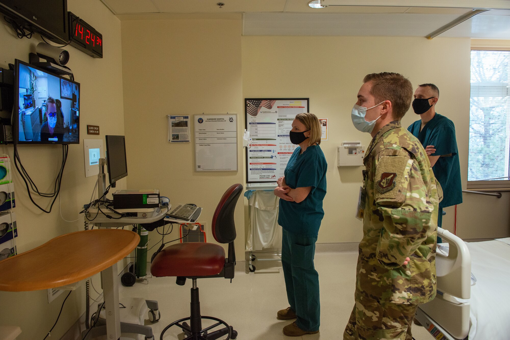 U.S. Air Force 1st Lt. Nicholas Westphalen, front, an intensive care unit clinical care nurse with the 673d Inpatient Operations Squadron, views a telemedicine television screen with U.S. Air Force Col. Kirsten Aguilar, center, Joint Base Elmendorf-Richardson and 673d Air Base Wing commander, and U.S. Air Force Chief Master Sgt. Lee Mills, JBER and 673d ABW command chief, at JBER, Alaska, Feb 26, 2021. The tour familiarized base leadership with the 673d IPTS and its role in supporting readiness. The 673d IPTS provides a full range of medical care to include perinatal care, intensive care, and behavioral health services to JBER and the greater Anchorage area.
