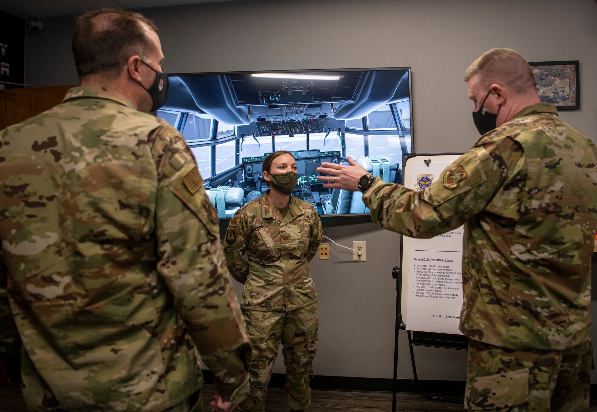 Chief Master Sgt. Chad Bickley, 18th Air Force command chief, right, and Maj. Gen. Thad Bibb, 18th AF commander, left, speak with Maj. Lacey Koelling, 317th Maintenance Group maintenance operation flight commander, about the virtual reality lab at Dyess Air Force Base, Texas, Mar. 3, 2021.