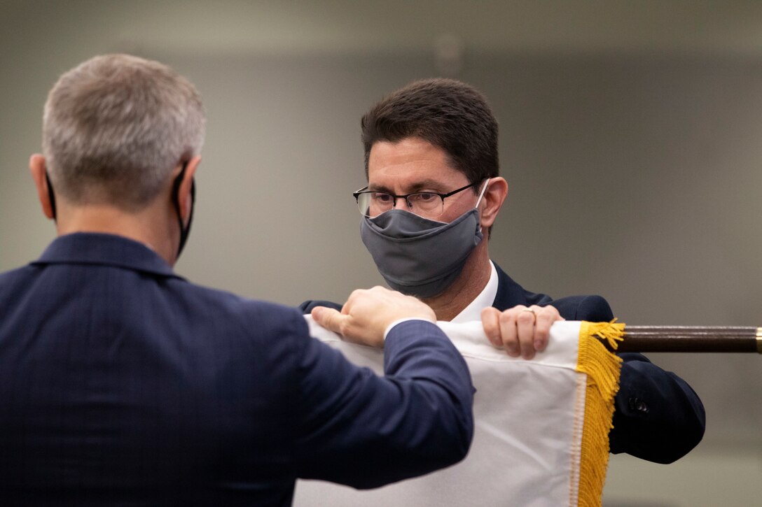 Dr. Edmond Russo, director of the U.S. Army Engineer Research and Development Center’s (ERDC) Environmental Laboratory (EL), unfurls the Senior Executive Service (SES) flag with ERDC Director Dr. David Pittman. The flag unfurling was part of a hybrid virtual and in-person SES induction ceremony held at the ERDC-EL building in Vicksburg, Miss., March 11, 2021.