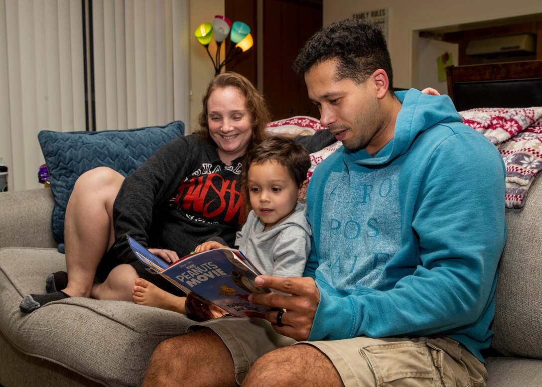 U.S. Marine Corps Staff Sgt. Felicia White, a supply chief with Camp Kinser Post Office, and Nicholas White read their son a book before bed on Camp Foster, Okinawa, Japan, Mar. 2, 2021. On Jan. 11, 2021, active duty personnel were permitted to receive the vaccine. As service members receive the second dose of the vaccine, they are given a sticker stating ‘I got my COVID-19 vaccine because…’ This personal memento signifies their own unique reason to receive the vaccine. White is a native to El Paso, Texas. (U.S. Marine Corps photo by Lance Cpl. Zachary Larsen)