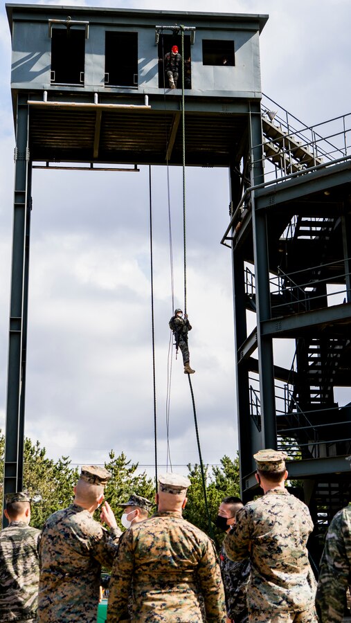 U.S. Marines, bottom, with 3rd Battalion, 3rd Marine Regiment, 3rd Marine Division, observe a Republic of Korea (ROK) Marine rappel down a rappel tower at a site survey of the 1st ROK Marine Division (ROKMARDIV) Mountain Warfare Training Complex at the 1st ROKMARDIV Base, Pohang, ROK March 8, 2021. U.S. Marines from 3rd Battalion, 3rd Marine Regiment conducted a site survey with ROK Marines from 2nd Battalion, 3rd Marine Brigade, 1st ROKMARDIV, of multiple training areas located around the city of Pohang where Korean Marine Exchange Program 21-2 will be held. (U.S. Marine Corps photo by Cpl. Ryan H. Pulliam)