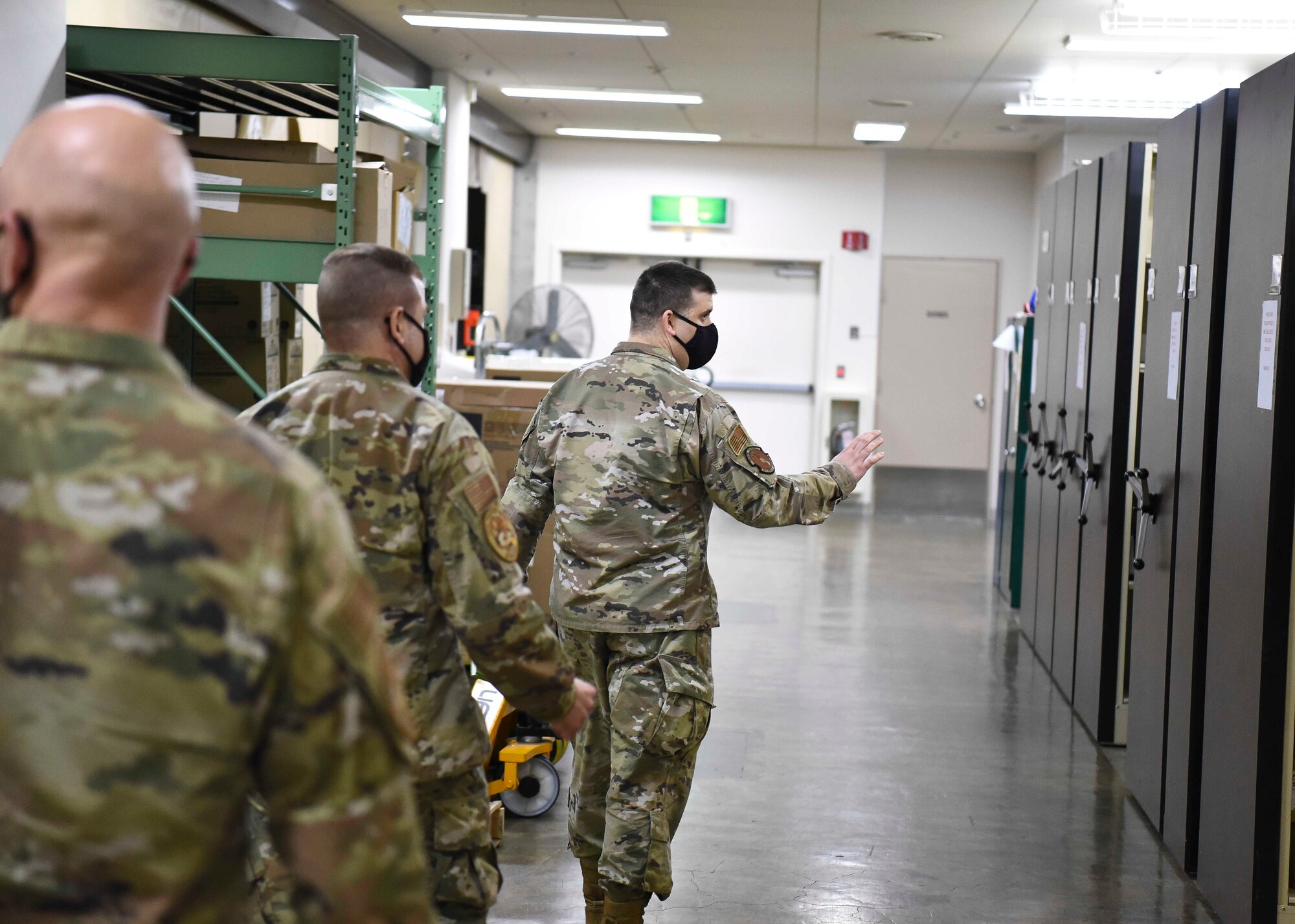 U.S. Air Force Tech. Sgt. Darren Smith, a Clinical Engineering section chief, directs Col. Jesse Friedel, the 35th Fighter Wing commander, and Chief Master Sgt. Joey Meininger, the 35th FW command chief, into the storage room of the medical facility during a Wild Weasel Walk-Through at Misawa Air Base, March 9, 2021.