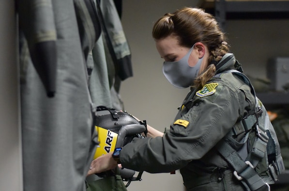 Pilot with pony tail putting on gear