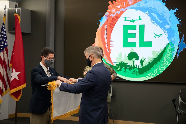 Dr. Edmond Russo, left, director of the U.S. Army Engineer Research and Development Center’s (ERDC) Environmental Laboratory (EL), unfurls the Senior Executive Service (SES) flag with ERDC Director Dr. David Pittman during a hybrid virtual and in-person SES induction ceremony held at the ERDC-EL building in Vicksburg, Miss., March 11, 2021.