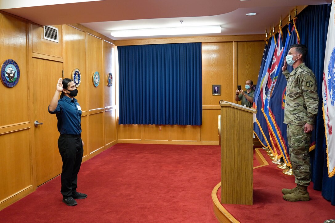 Reyjie Cliff Blando Madriaga, a Hawaiian native, receives the oath of enlistment from U.S. Army Capt. Donald McCoullough, Honolulu Military Entrance Processing Station officer, and swears in as the first Hawaiian U.S. Space Force recruit at Joint Base Pearl Harbor-Hickam, Hawaii, March 4, 2021. The oath of enlistment is a promise made by members of the United States Armed Forces to support and defend the Constitution. (U.S. Air Force photo by Airman 1st Class Makensie Cooper)