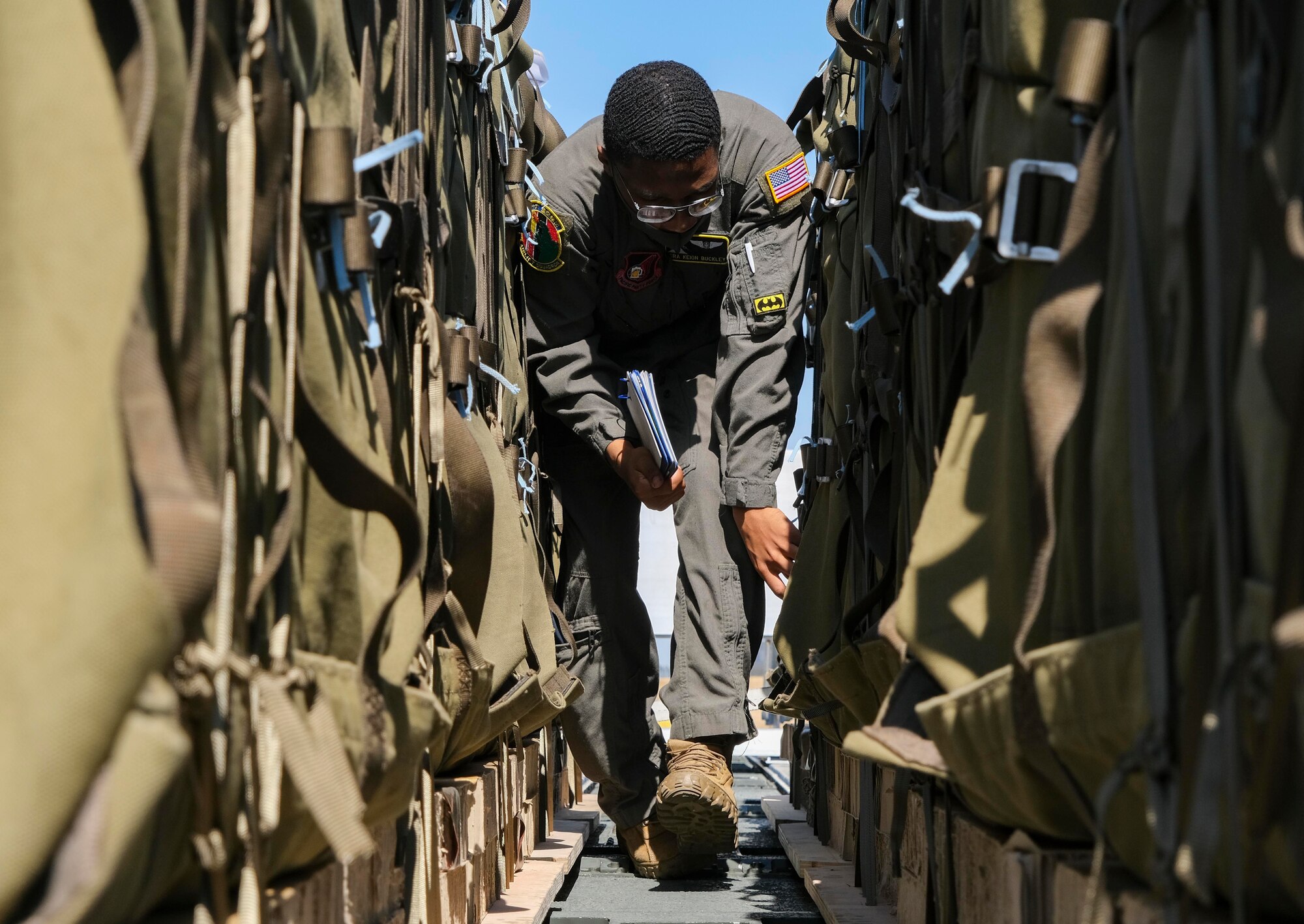 Senior Airman Keion Buckley, 36th Airlift Squadron loadmaster, checks Japan Ground Self-Defense Force container delivery system bundles prior to their upload onto a C-130J Super Hercules for an equipment airdrop as part of exercise Airborne 21 at Yokota Air Base, Japan, March 10, 2021.