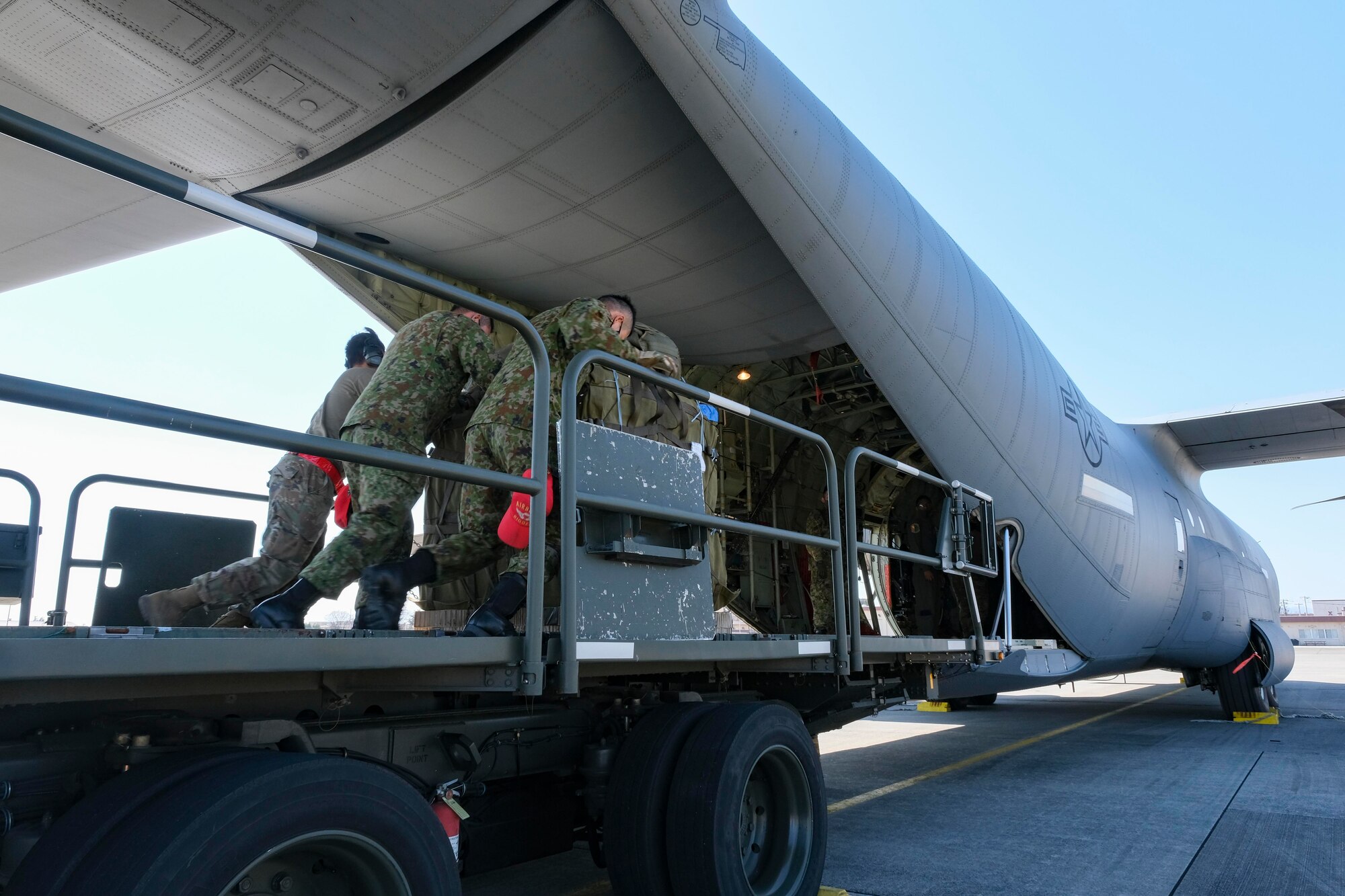 374th Logistics Readiness Squadron Combat Mobility Flight Airmen and Japan Ground Self-Defense Force personnel load JGSDF container delivery system bundles onto a C-130J Super Hercules for an equipment airdrop as part of exercise Airborne 21