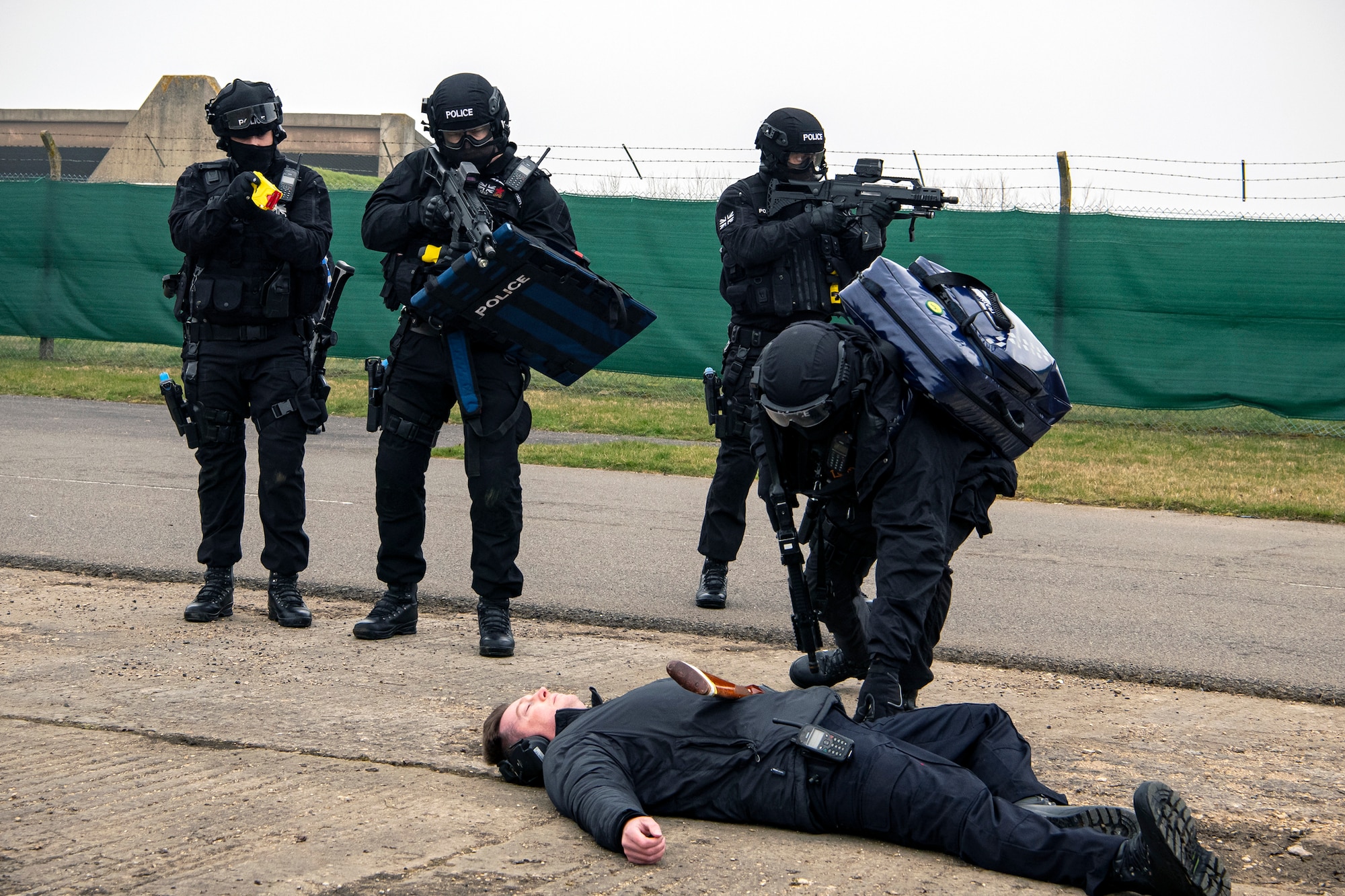 Policemen from the Northamptonshire Police Department, apprehend a simulated active shooter during a field training exercise at RAF Croughton, England, March 3, 2021. The NHPD utilized the 422d Security Forces Squadron training complex to help strengthen their tactics and techniques. Events like this help strengthen the local partnership between the 422d SFS and the NHPD. (U.S. Air Force photo by Senior Airman Eugene Oliver)