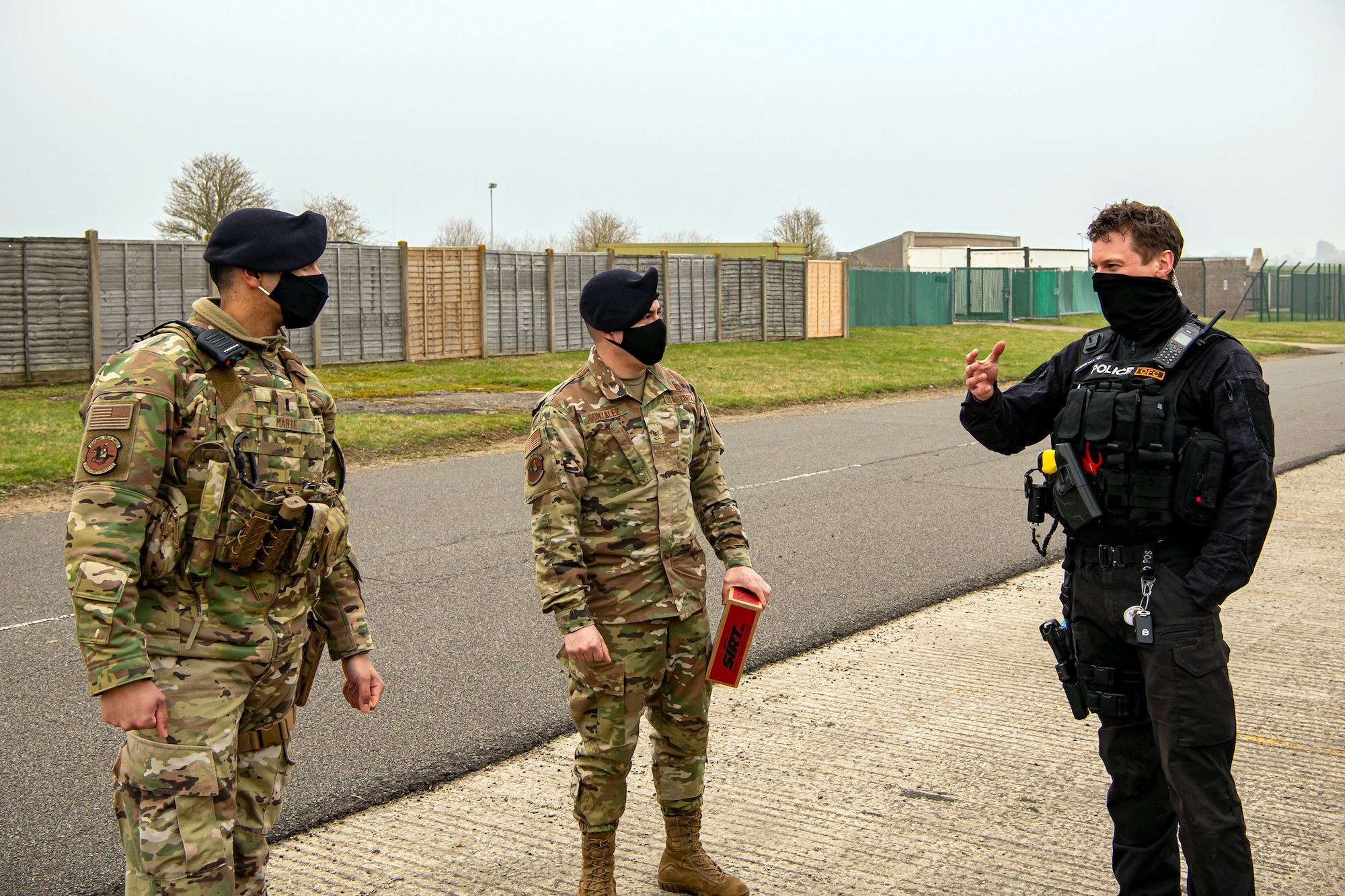 A policeman from the Northamptonshire Police Department, speaks with 1st Lt. George Marte, left, 422d Security Forces Squadron operations officer, and Staff Sgt. Alvaro Gonzalez, 422d SFS unit trainer, after a field training exercise at RAF Croughton, England, Mar. 3, 2021.  The NHPD utilized the 422d SFS training complex to help strengthen their tactics and techniques. Events like this help strengthen the local partnership between the 422d SFS and the NHPD. (U.S. Air Force photo by Senior Airman Eugene Oliver)