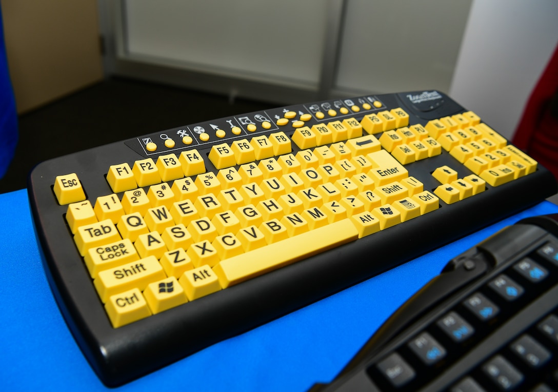 A keyboard with yellow keys and large print sits on a table.