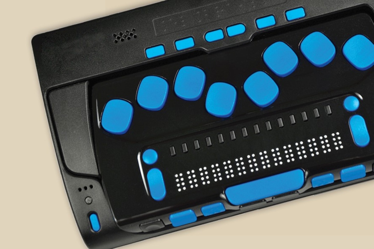 A special keyboard has several blue buttons and a line of Braille.