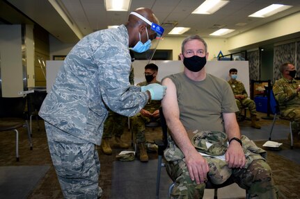 Capt. Albert Scott Jr., 433rd Medical Squadron critical care nurse, administers a COVID-19 vaccine to Col. Terry W. McClain, 433rd Airlift Wing commander, at Joint Base San Antonio-Lackland, Texas March 6, 2021. McClain was in the first group of members to receive the vaccine. (U.S. Air Force photo by Senior Airman Brittany Wich)