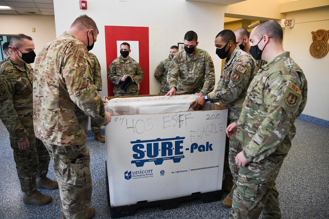 Members of the 66th Security Forces Squadron unpack memorials for Senior Airmen Kcey Ruiz and Nathan Sartain at Hanscom Air Force Base, Mass., March 10.