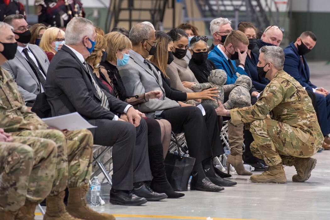 U.S. Air Force Master Sgt. Chris Taylor, chief of the 167th fire department presents London Brown with two teddy bears made from Staff Sgt. Logan Young’s uniform during a memorial service held at the 167th Airlift Wing, Shepherd Field, Martinsburg, West Virginia, March 6, 2021. Brown was engaged to Young who died while fighting a fire in December.
