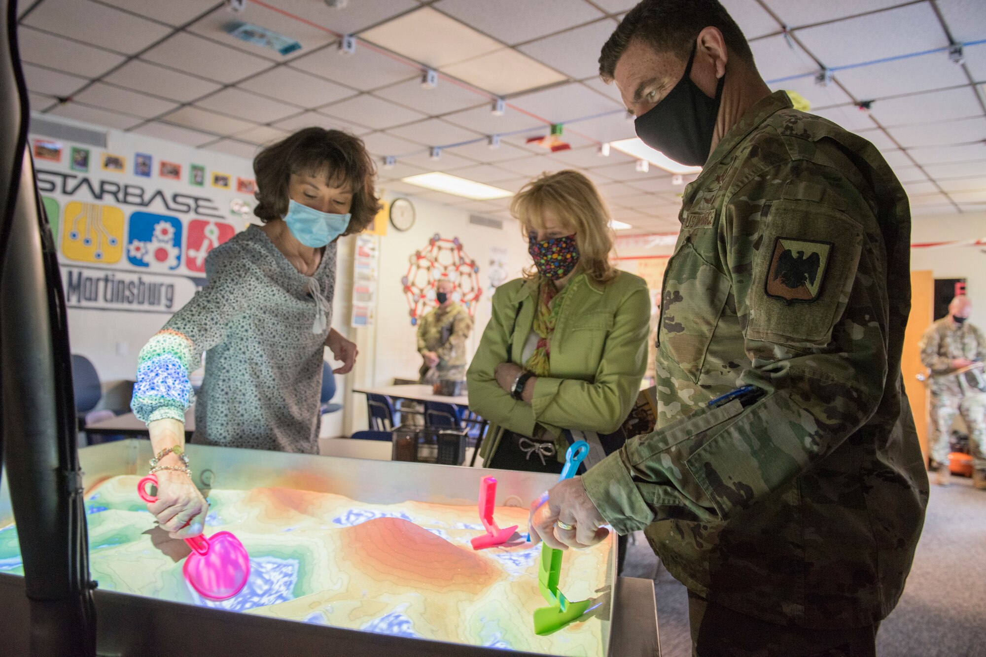 Sherra Triggs, left, director of STARBASE Martinsburg, speaks with U.S. Air Force Lt. Gen. Michael A. Loh, director, Air National Guard, and his wife Diane Loh, about teaching STARBASE curriculum through the COVID-19 pandemic, during their visit to the 167th Airlift Wing, West Virginia National Guard, at Shepherd Field Air National Guard Base in Martinsburg, West Virginia, March 9, 2021. During his visit, Loh received updates on the unit’s current operations and response to the COVID-19 pandemic