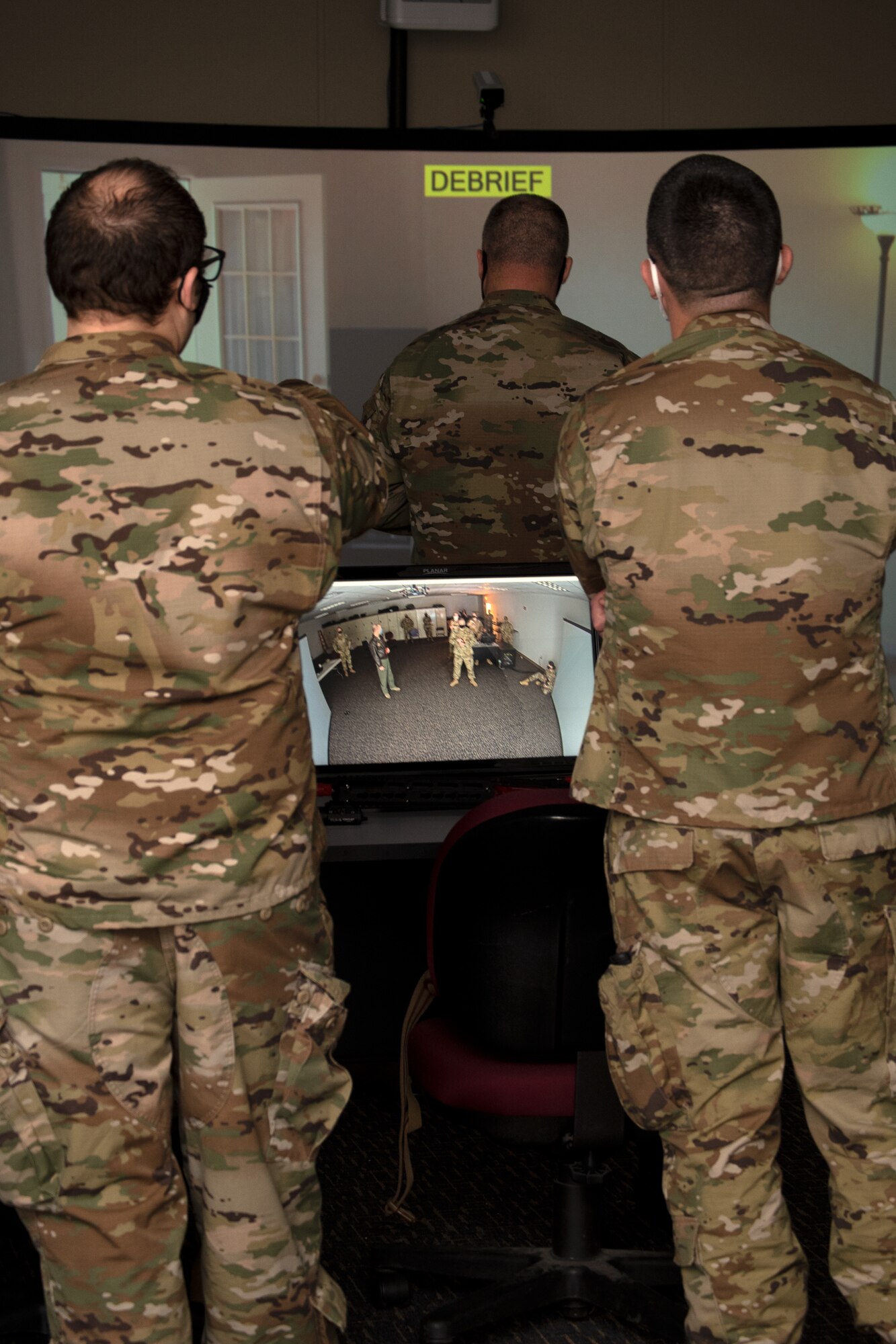 Master Sgt. Justin Benz and Technical Sgt Christopher Fulton provide a debrief for a scenario completed using the MILO Firearms Training Simulator the unit recently purchased with Squadron Innovation Funds.