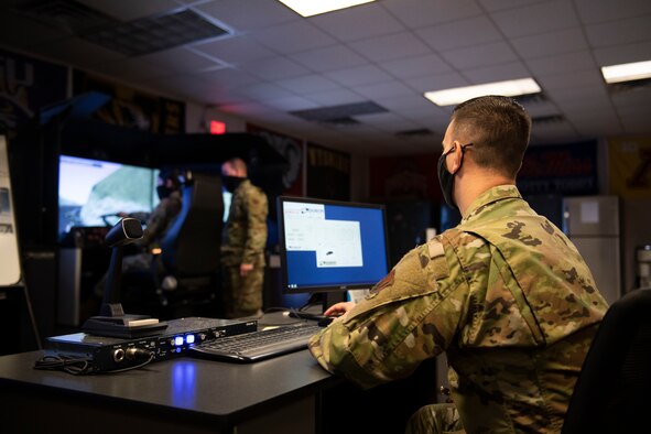 Man operates the control panel of a truck simulator