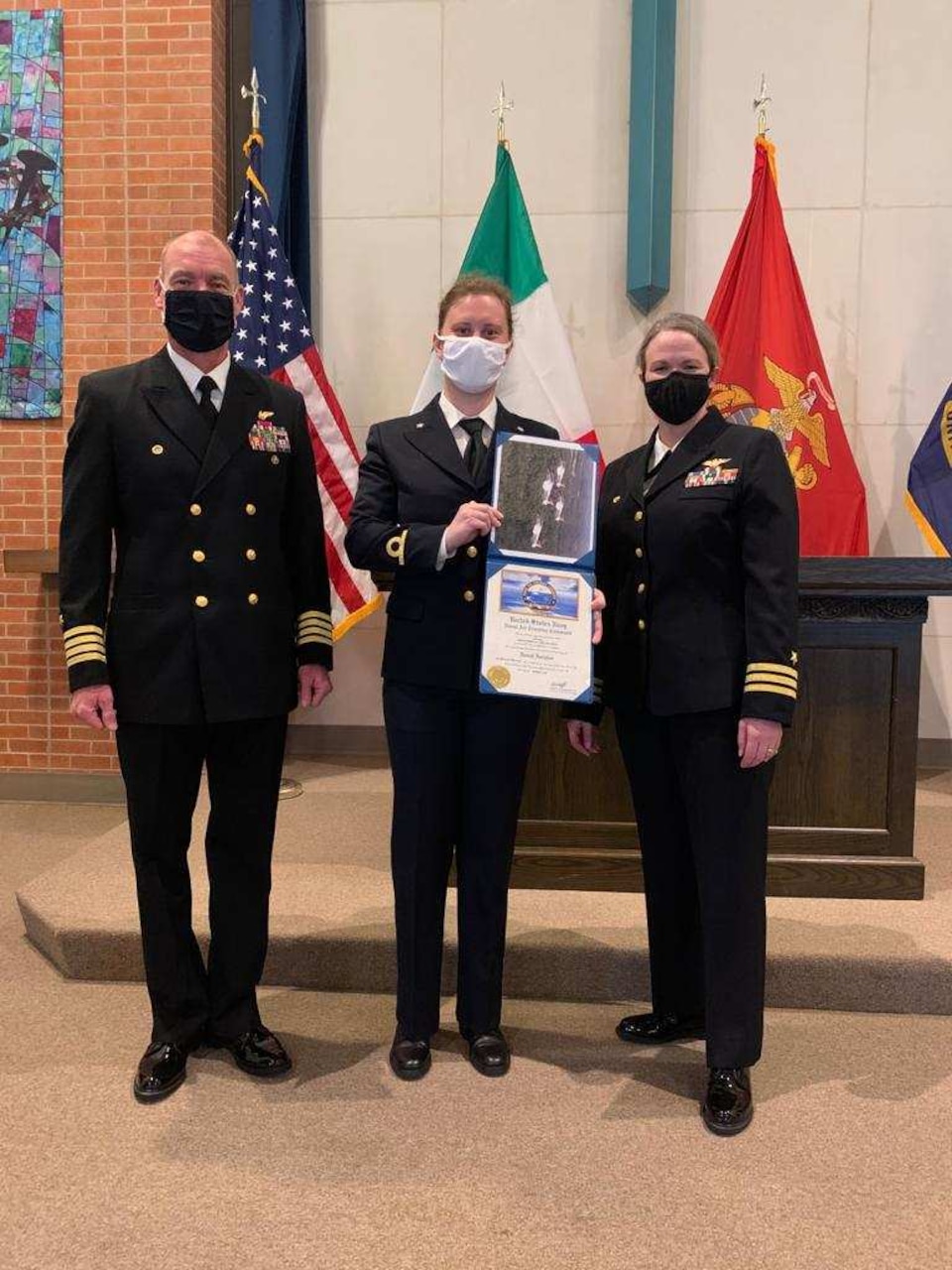 Italian navy Ensign Erika Raballo, center, stands with Commodore, Training Air Wing 1 Capt. Tracey Gendreau, left, and Training Squadron (VT) 9 Commanding Officer Cmdr. Meghan Angermann during her winging ceremony at Naval Air Station Meridian base chapel, March 11.